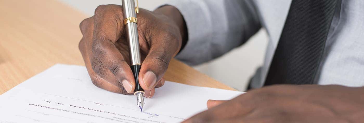 a person signing a paper