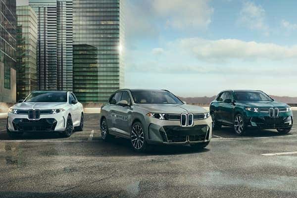 Three BMW SUVs parked together in an urban setting