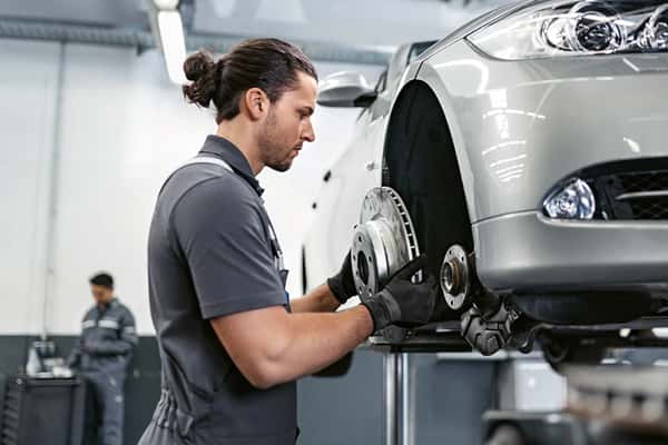 BMW technician replacing a front brake rotor