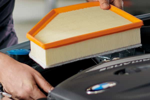 Technician installing a new BMW engine air filter