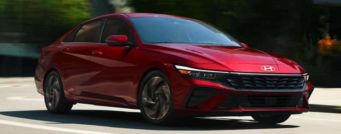 Red 2026 Hyundai Elantra driving on the road.
