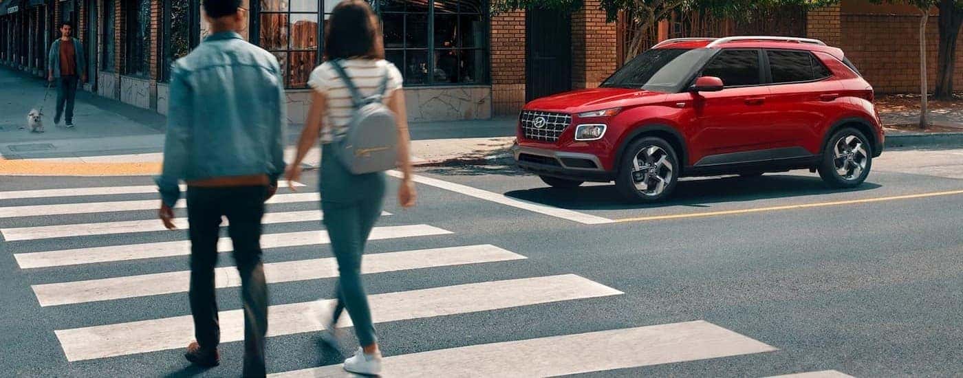 A red 2026 Hyundai Venue stopped at a crosswalk.