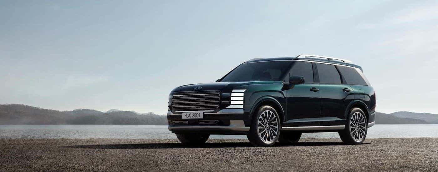 A green 2026 Hyundai Palisade parked near water.
