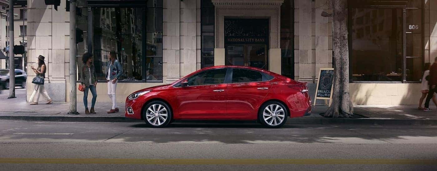 A red 2020 Hyundai Accent parked by a shop.