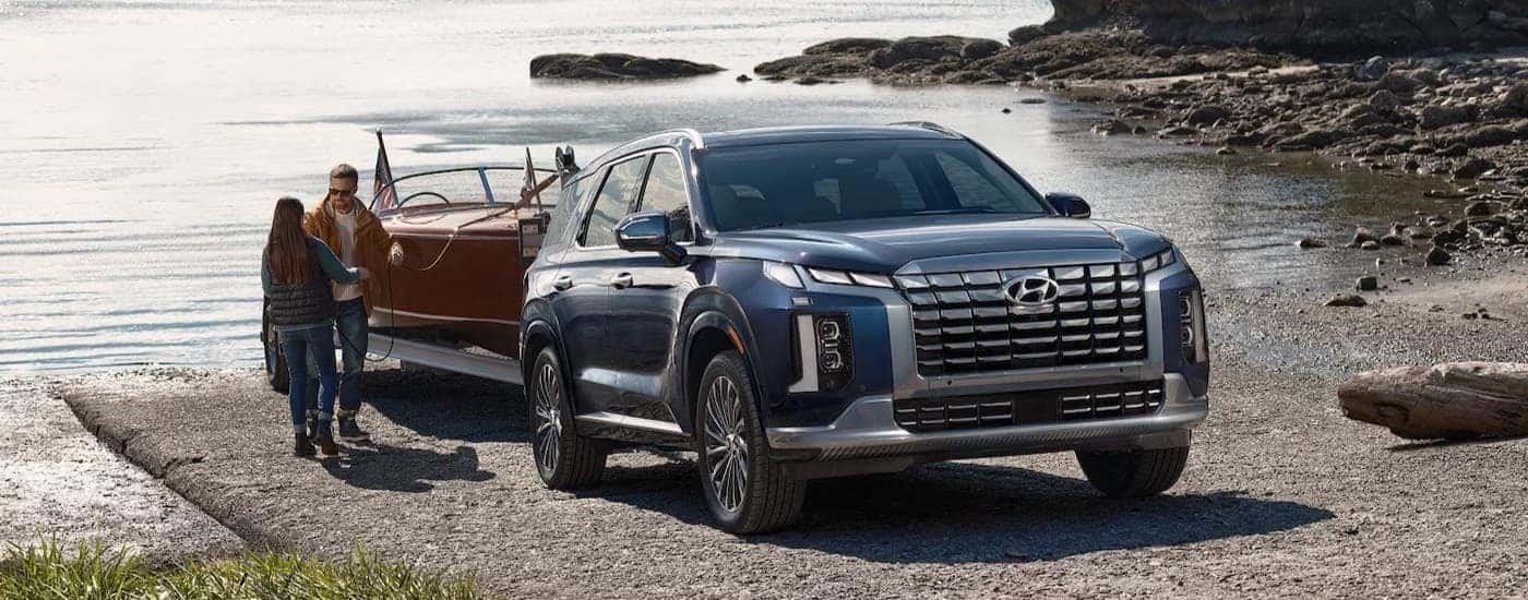 A green 2026 Hyundai Palisade towing a boat.
