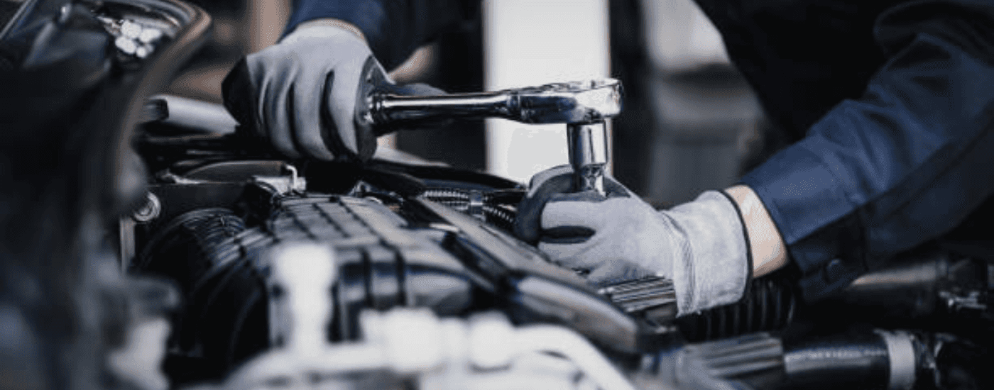 A mechanic tightens down a bolt with a socket wrench