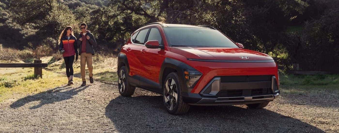 Hikers near a parked red 2026 Hyundai Kona.