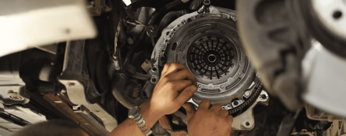 A person loosening a bolt in a transmission