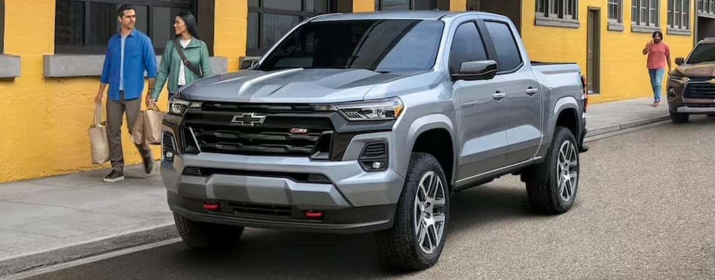 A silver 2023 Chevy Colorado Z71 is shown parked near a Chevy dealer.