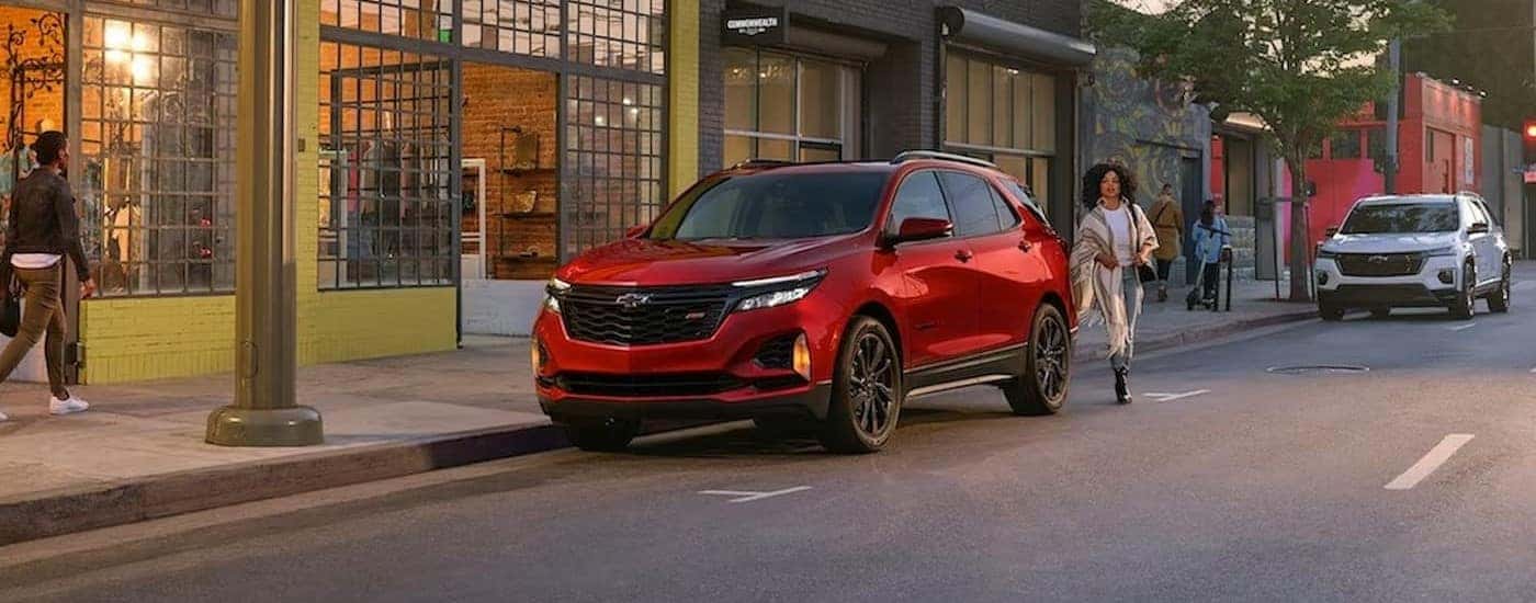 A red 2024 Chevy Equinox RS is shown parked near a store.