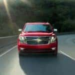 A red 2020 Chevy Tahoe is driving around a corner on a mountain road.