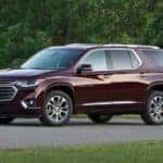A purple 2018 used Chevy Traverse is parked with trees in the background.