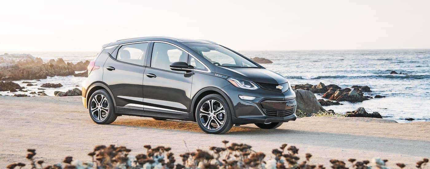 A black 2021 Chevy Bolt EV is parked on a beach.