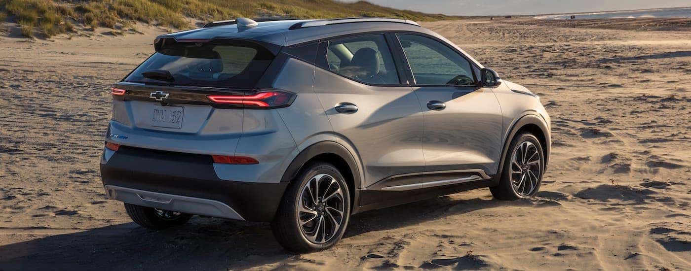 A silver 2022 Chevy Bolt EUV is shown from a rear angle while parked on a beach.
