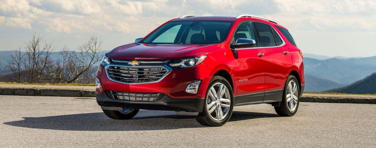 A red 2021 Chevy Equinox is shown parked in front of distant mountains after winning the 2021 Chevy Equinox vs 2021 Honda CR-V comparison.