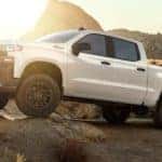 A white 2020 Chevy Silverado 1500 is off-roading in the desert after leaving a used Chevy Silverado dealer in KY.