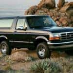 A black 1994 Ford Bronco XLT is shown parked with rocks in the background.