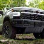 A white 2024 Chevy Silverado 1500 ZR2 Bison is shown parked near trees.