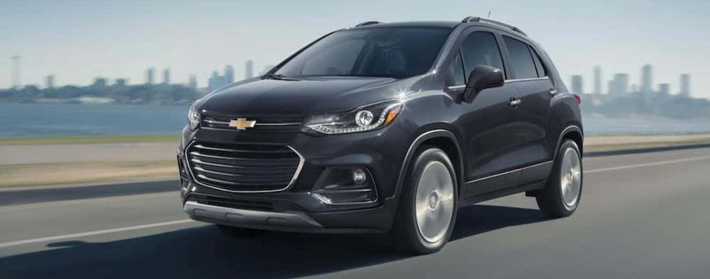 A gray 2020 Chevy Trax is shown driving near a city.