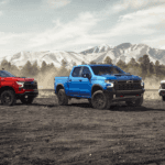 Three 2026 Chevrolet Silverado 1500 models parked against a mountainscape