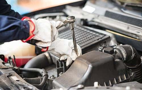 Halterman's Toyota is a Toyota Dealership near Analomink PA | Close up of mechanic hands working under the hood of Toyota vehicle