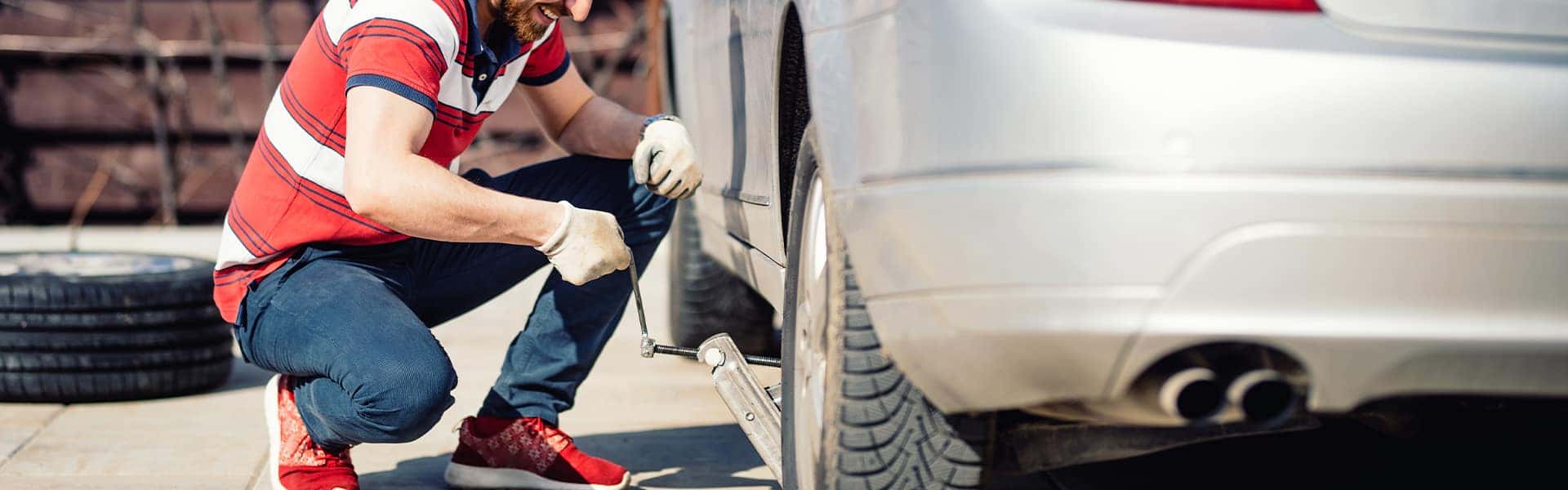 How to change a tire step-by-step guide at Halterman's Toyota in East Stroudsburg | Man using Car Jack on Car in Order to Lift Up and Change Tire on Vehicle