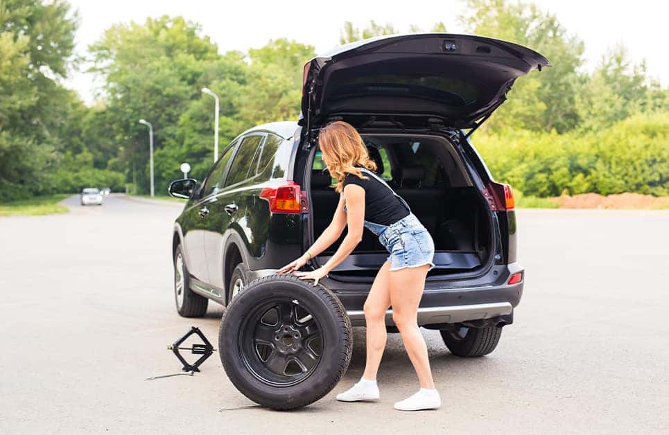 How to change a tire step-by-step guide at Halterman's Toyota in East Stroudsburg | Woman Rolling Spare Tire After Getting it Out of Her Trunk