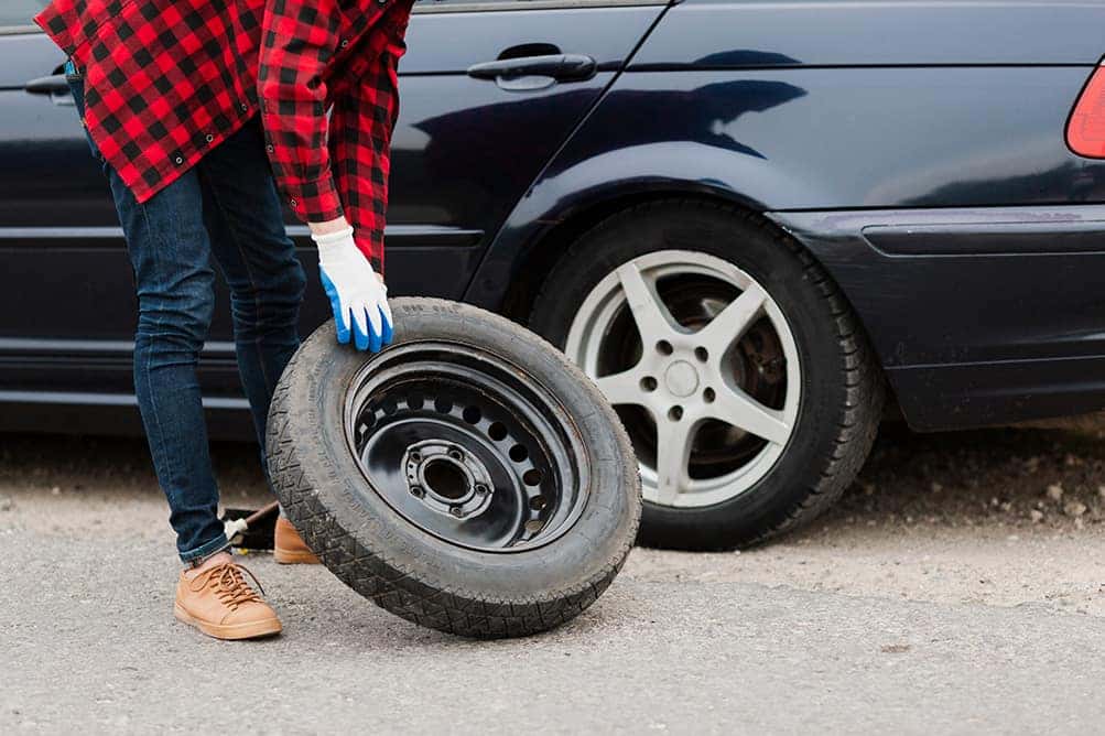 A step-by-step guide to changing a tire by Halterman's Toyota in East Stroudsburg | Man taking spare tire out of trunk
