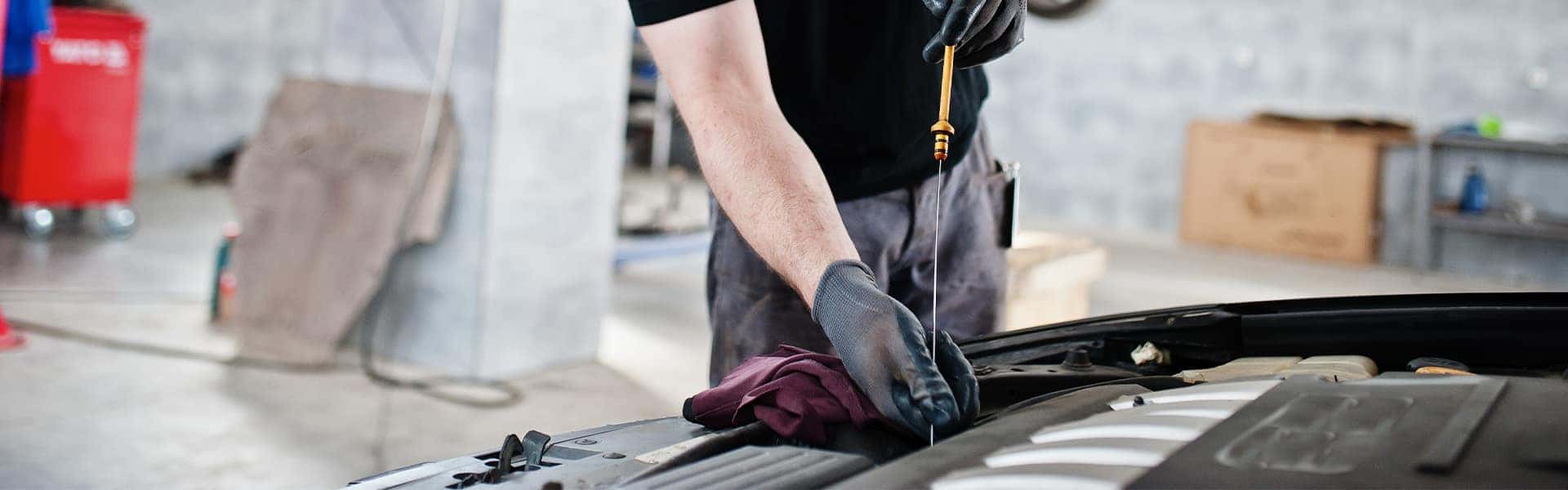 Difference between synthetic oil & conventional oil at Halterman's Toyota | Service Advisor Taking Oil Dip Stick Out of Engine