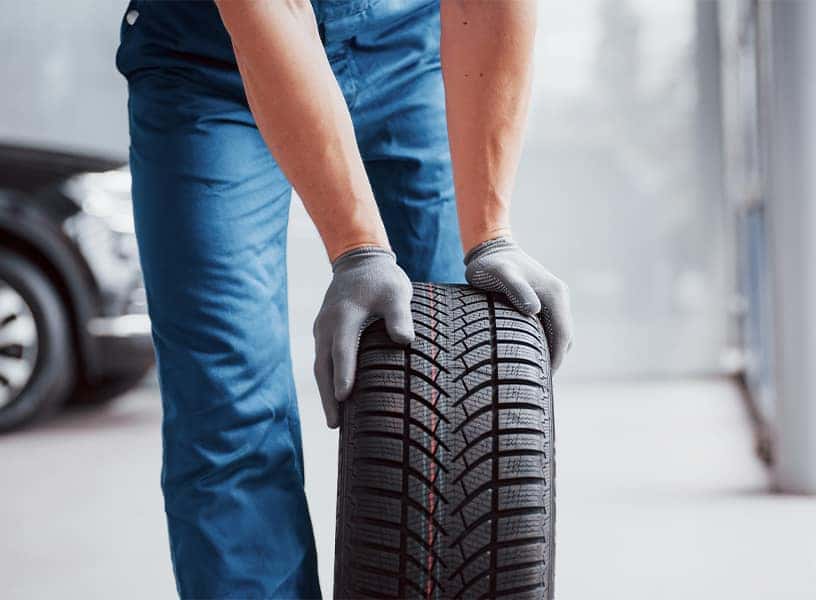 what different tire options are available at Halterman's Toyota in East Stroudsburg | Service Advisor Rolling Tre Around to Vehicle in Service Bay