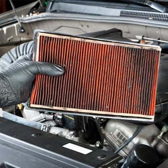 Everything You Need to Know About Cabin Air Filters | Close-up of dirty air filter being held by glove