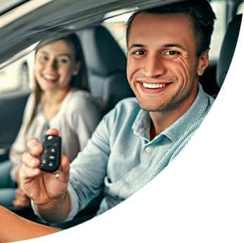 Defining APR at Halterman's Toyota in East Stroudsburg, PA | Happy couple sit in new car and driver shows off keys