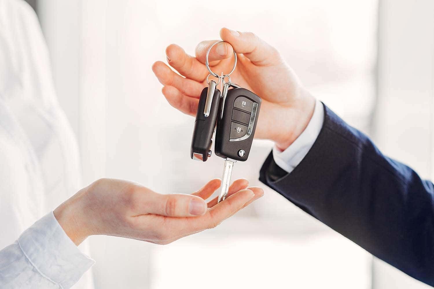 Leasing versus Buying a Toyota at Halterman's Toyota in East Stroudsburg, PA | Salesman handing a customer keys to her new leased vehicle