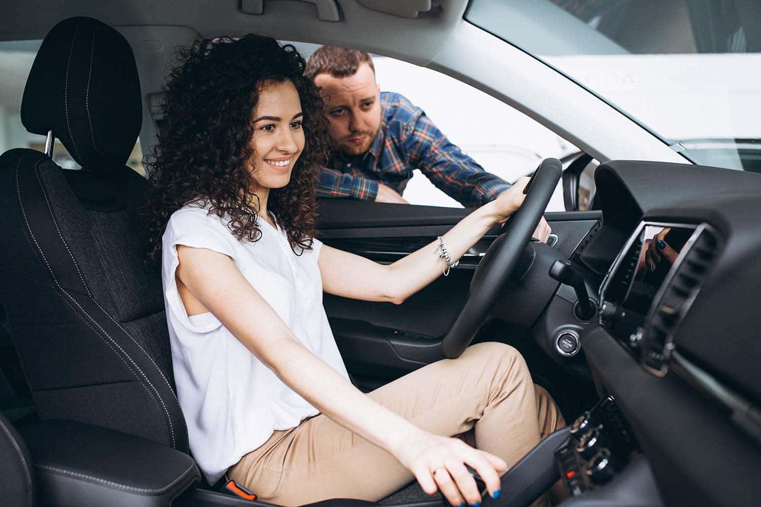 Leasing versus Buying a Toyota at Halterman's Toyota in East Stroudsburg, PA | Couple testing new vehicle in showroom