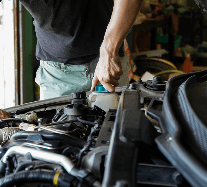 How to Get Your Car Summer Ready at Halterman's Toyota in East Stroudsburg, PA | Man in black shirt opening the lid of a coolant reservoir