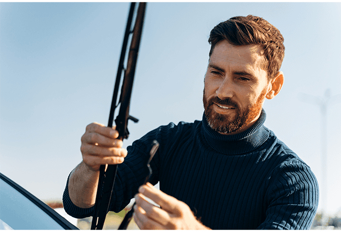 How to Get Your Car Summer Ready at Halterman's Toyota in East Stroudsburg, PA | Man in Navy blue sweater is changing out his cars windshield wipers on a nice sunny day