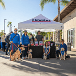 Humane Society of San Diego Volunteers and dog ambassadors stand with Audi Carlsbad GM Max Johnson at our Four Rings & Four Paws Event