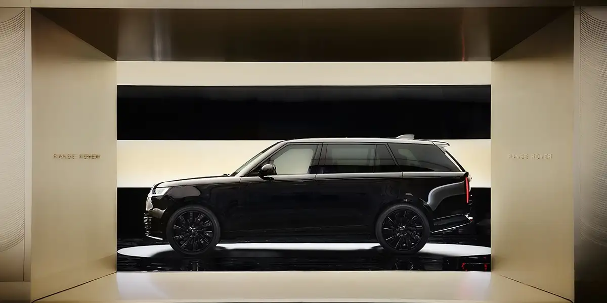 Side profile of the 2025 Land Rover Defender 90 driving across an open landscape