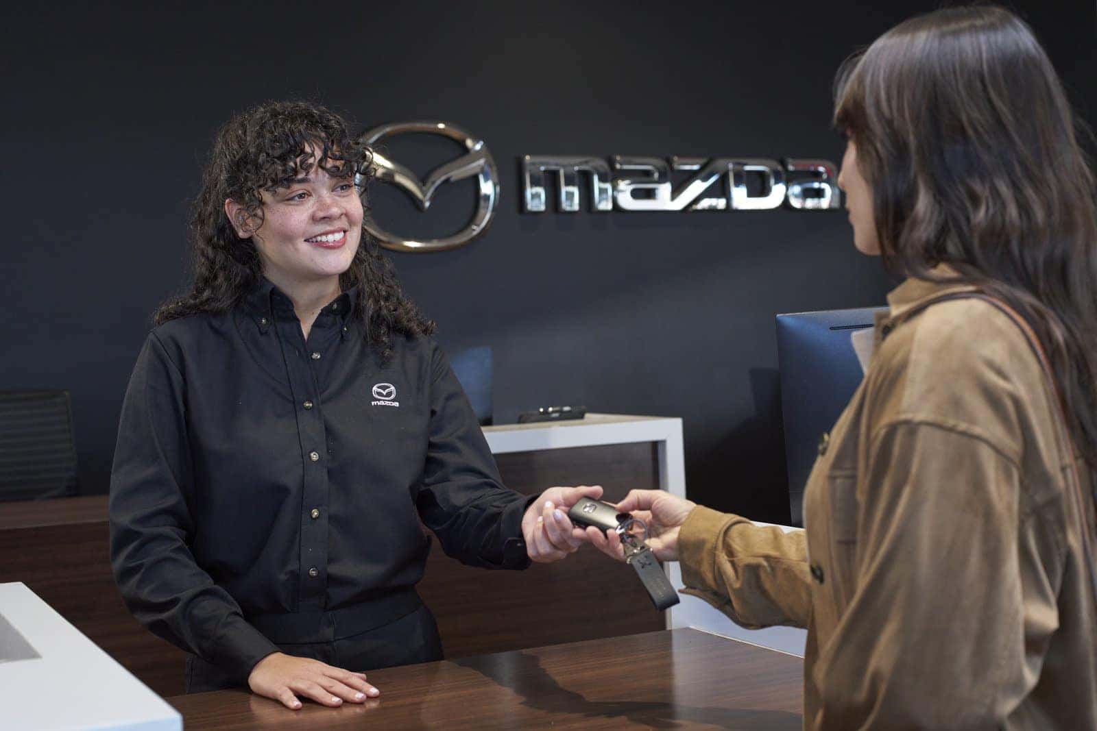 A Mazda of Gladstone team member handing car keys to a customer