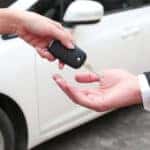ls vegas used car salesman giing car keys to buyer with car in the background