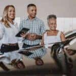 man and woman looking at a used car for sale in Las Vegas with a used car sales person