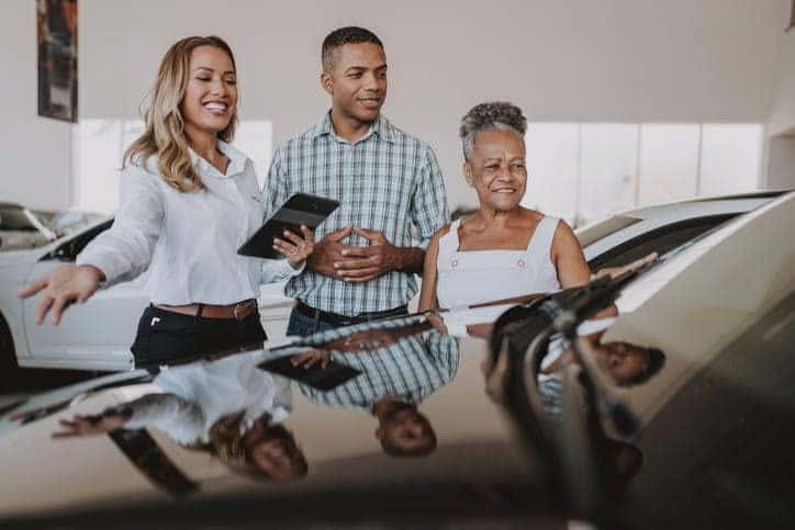 man and woman looking at a used car for sale in Las Vegas with a used car sales person