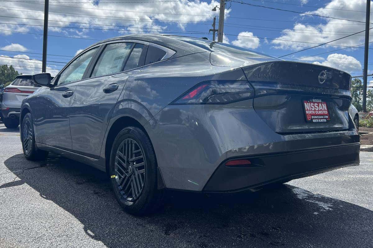 2027 Nissan Sentra Gun Metallic rear three-quarter exterior driver side view