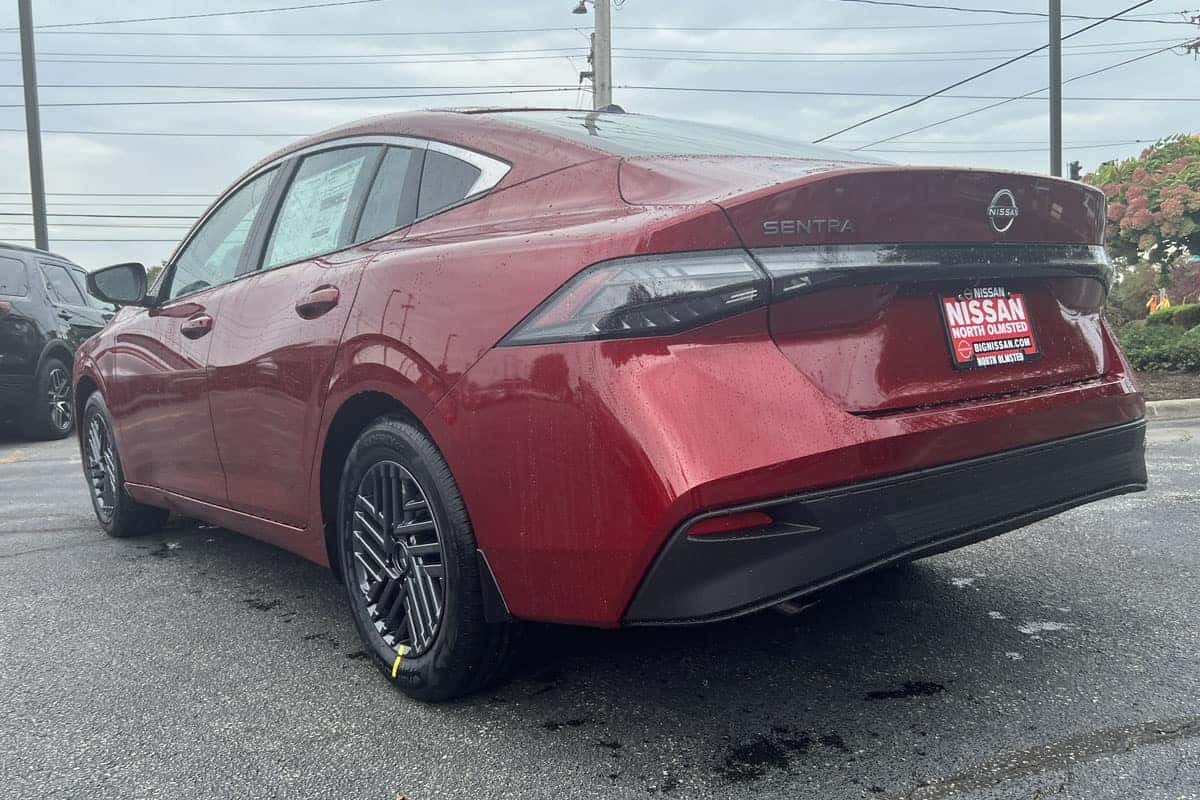 Rear driver side three-quarter view of the 2027 Sentra in Scarlet Ember Red exterior color near Cleveland, Ohio.