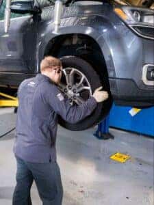 A person inspecting a tire for wear and tear, checking the tread depth and overall condition.