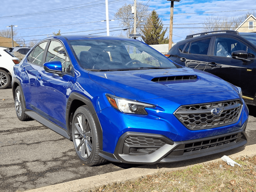 A blue Subaru WRX parked in a parking lot.