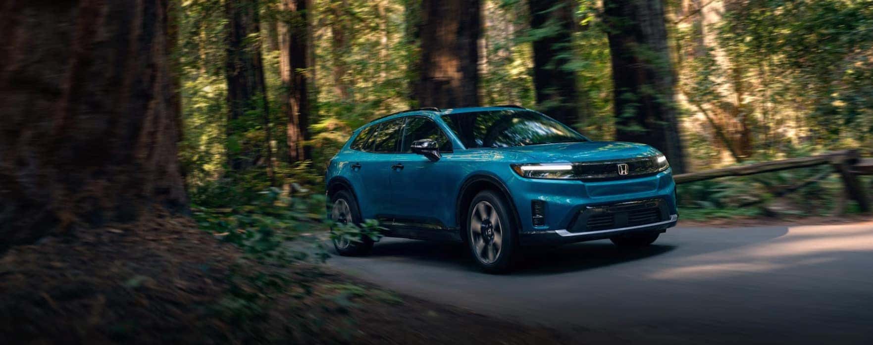 2024 Blue Honda Prologue driving along a mountain road