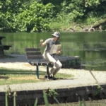 a well hatted lady on a park bench