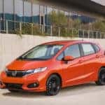 Orange Honda Fit parked in an urban setting