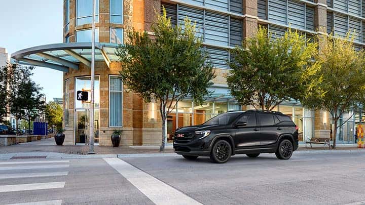 2021 GMC Terrain SLT Black Edition Exterior in Ebony Twilight Metallic; 7/8 Drivers side Front; Black Edition Includes 19" Gloss Black Aluminum Wheels, Darkened Grille / Grill Insert and Black Surround, Black Mirror Caps, Roof Rails, and Black Exterior Model and Trim Badging; On urban / city street